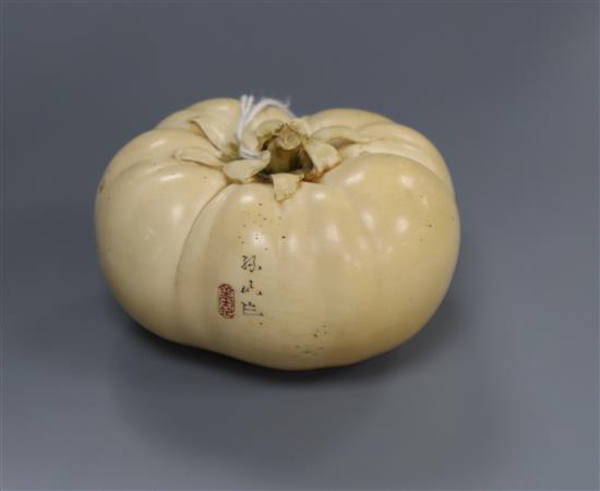 A good Japanese ivory model of a persimmon fruit, early 20th century, three character signature and seal, remnants of colouring to base